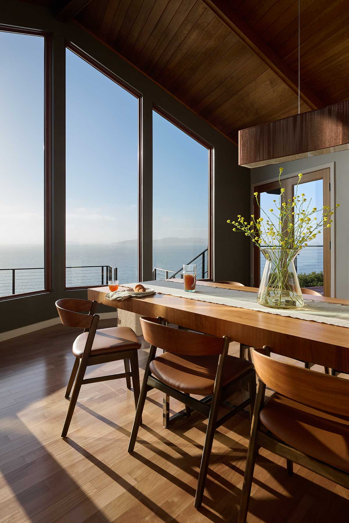 A modern living room overlooking a bay view in California through Marvin Ultimate polygon windows.