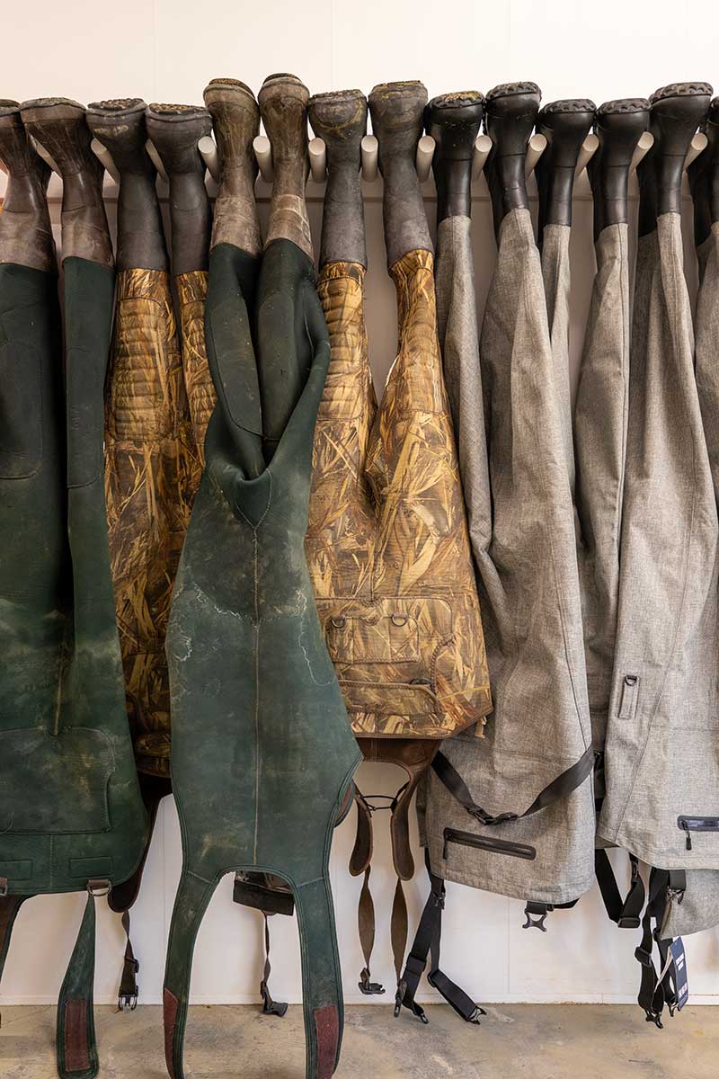 Waders hanging upside down on a wall.