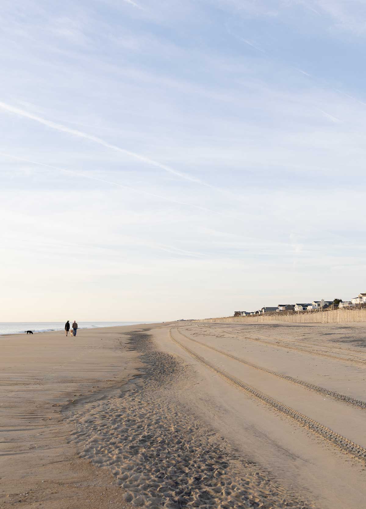 Two people walking along Bethany Beach in Delaware.