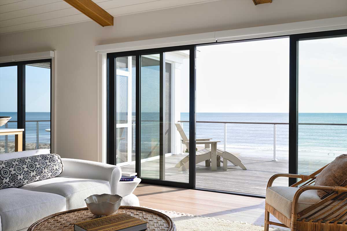 A Marvin Modern Multi-Slide door in a living room, with a view of the ocean from Bethany Beach, Delaware.