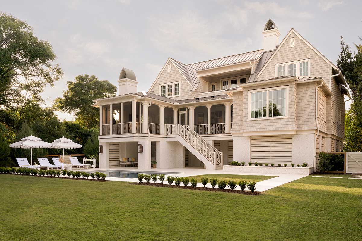 The exterior of a home in Charleston, SC, featuring Marvin windows, a four-season porch, and an in-ground swimming pool.