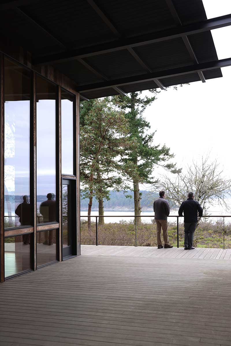 Peter Bates of Good Homes Construction and Dan Shipley of Shipley Architects looking out over Puget Sound from the Marrowstone Island residence.