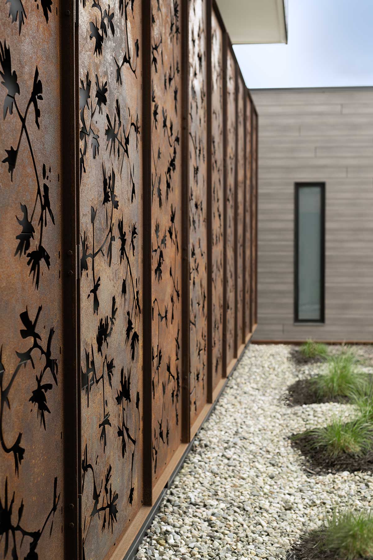 A close up photo of siding on a modern home in New Hampshire, featuring Marvin Modern windows and doors.