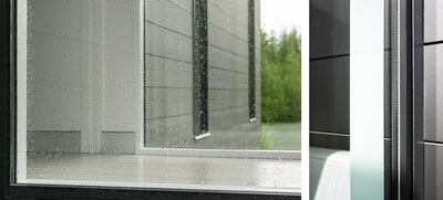 A close up of a Marvin Modern Direct Glaze window covered in raindrops.