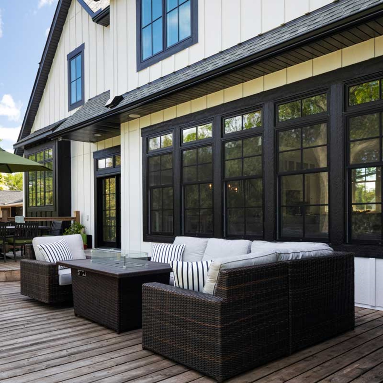 Wood patio with outdoor sectional in front of black marvin elevate windows