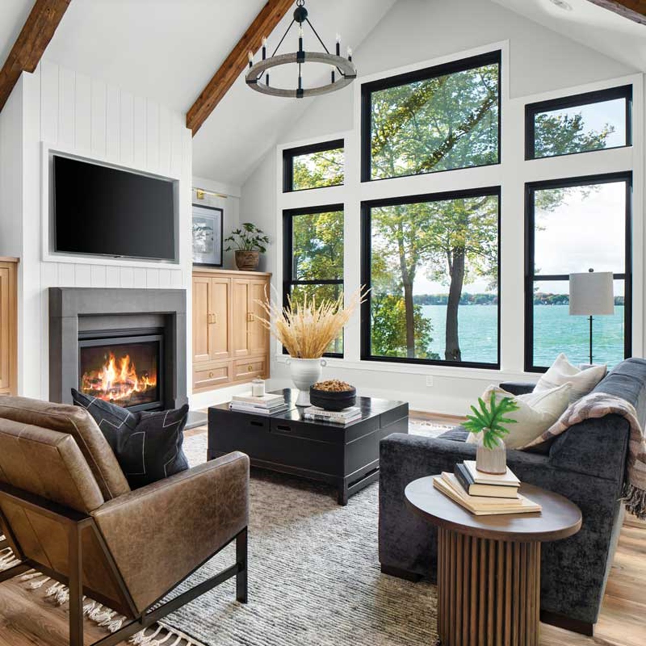 Living room with seating and fire place facing the view out black elevate windows