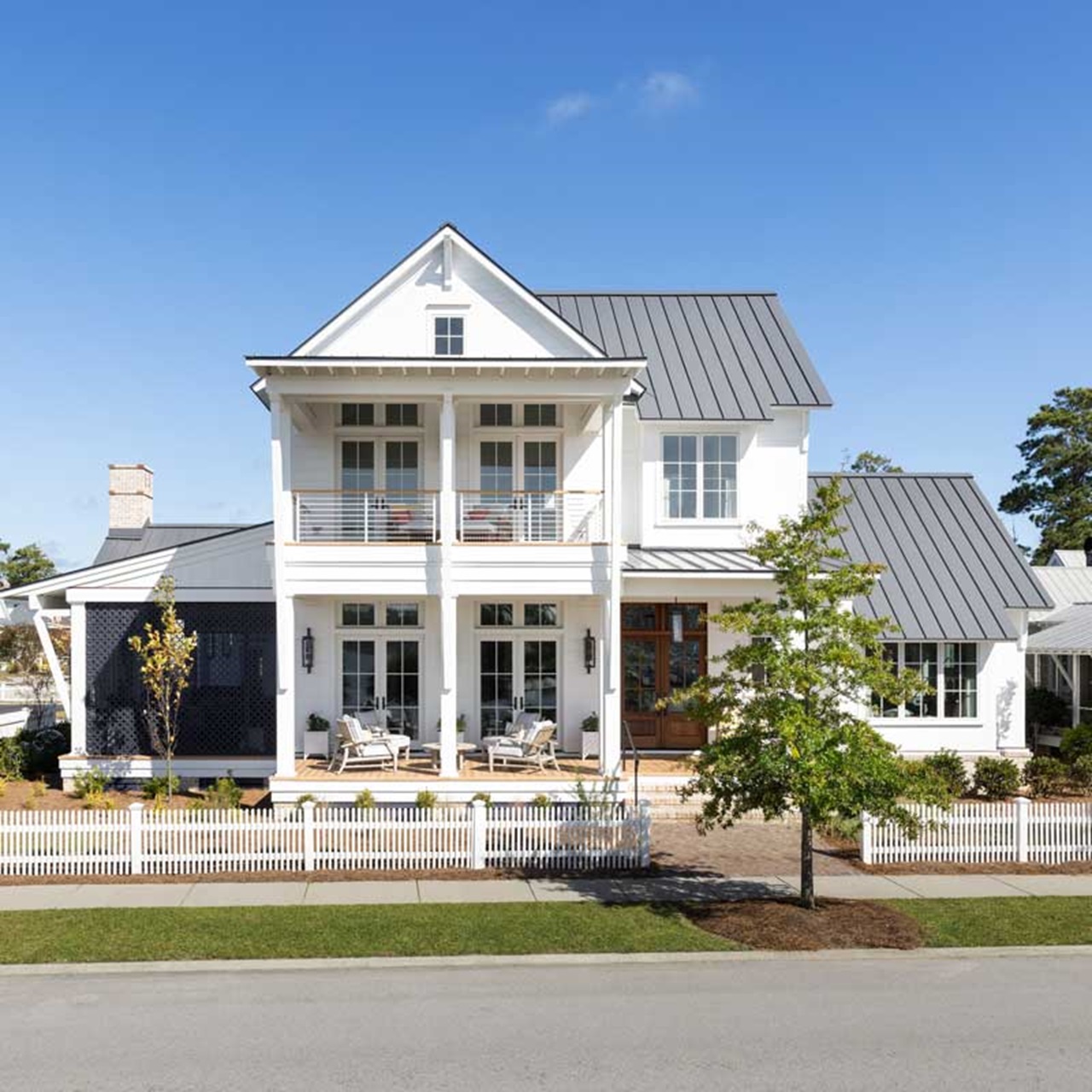 Exterior of white coastal home with white fence and white marvin elevate windows