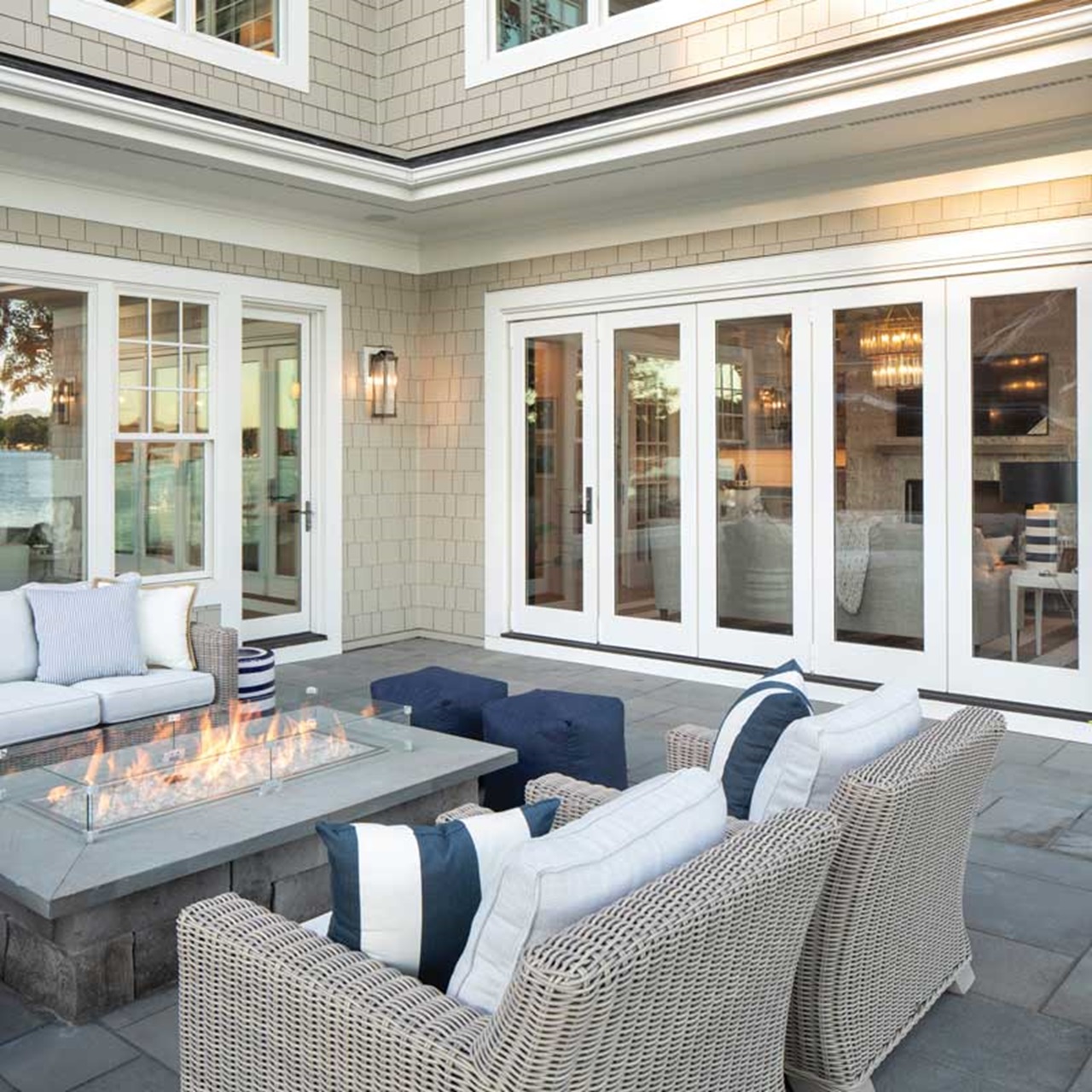 Outdoor patio with seating in front of white marvin elevate windows and patio door