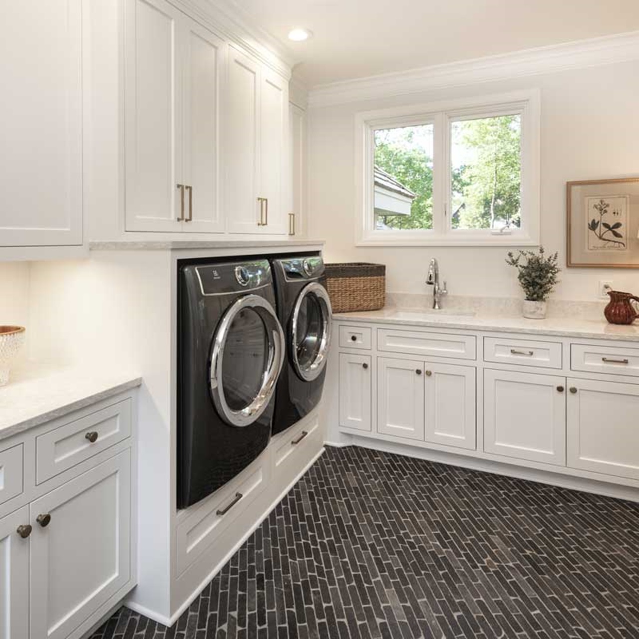 Laundry room with white cabinets and casement windows