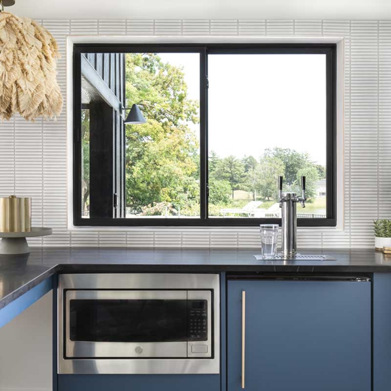 Kitchen with blue cabinets and black sliding window