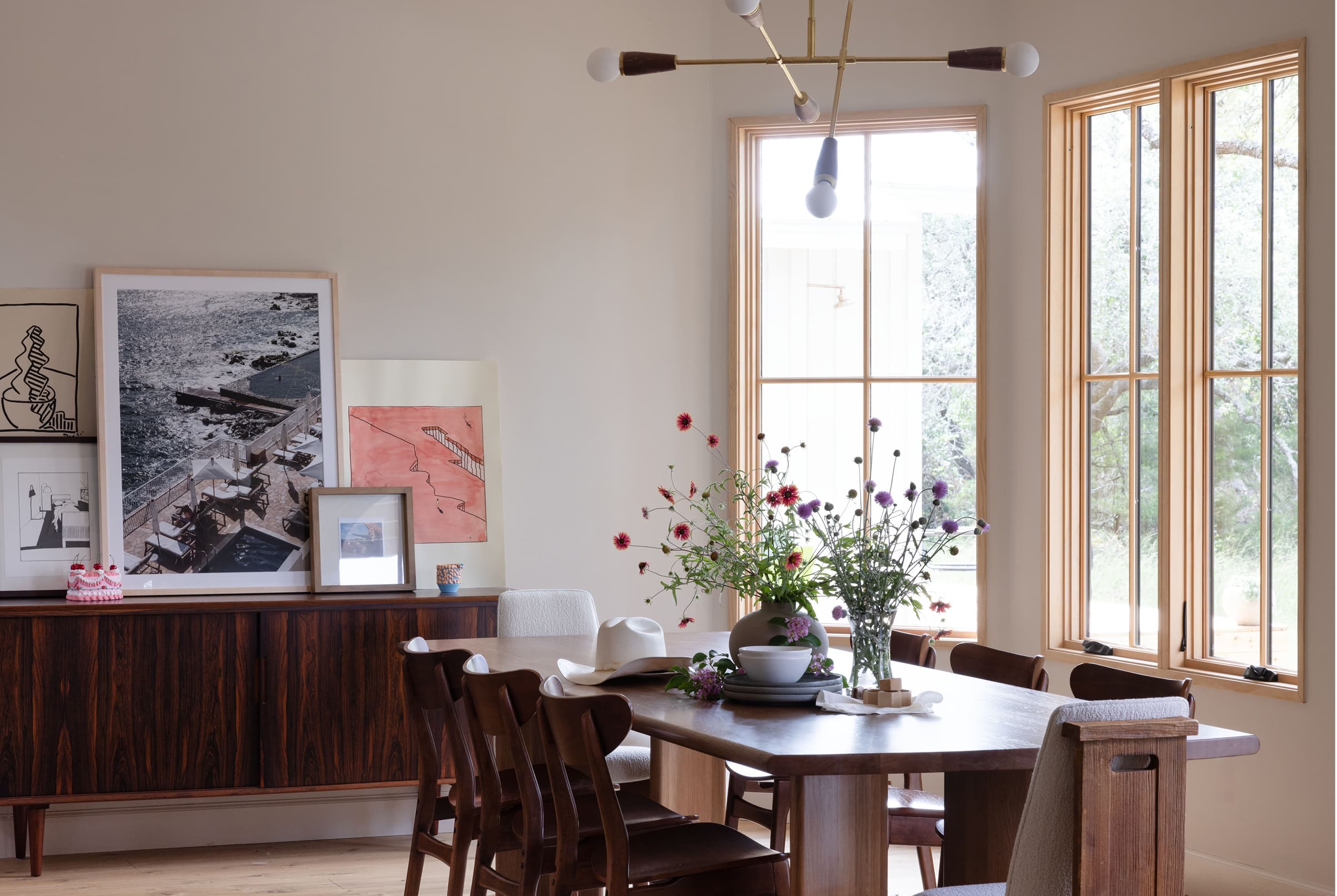 Dining room interior featuring a wood table, chairs and wood Marvin Elevate Casement windows with grilles.